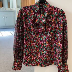 Tie neck blouse with sheer micro pleated sleeves.